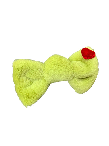 A neon green hair bow with a Grinch character detail on an alligator clip.