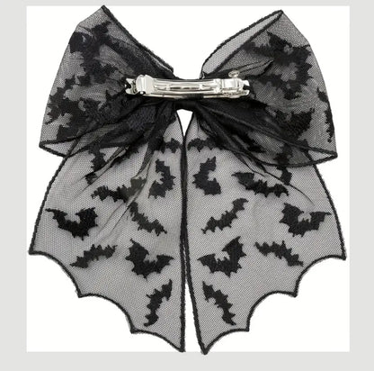 Black bat patterned bow hair clip on a white background