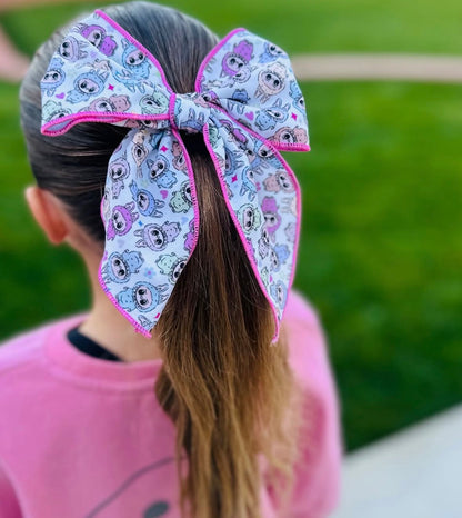 Large hair bow with cartoon character pattern on a blurred outdoor background