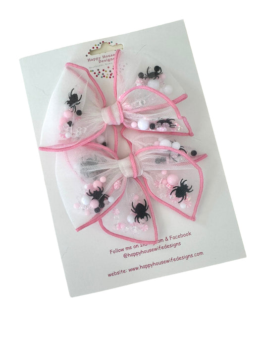 A collection of Halloween-themed shaker hair bows with various designs and colors, displayed on cards with alligator clips.