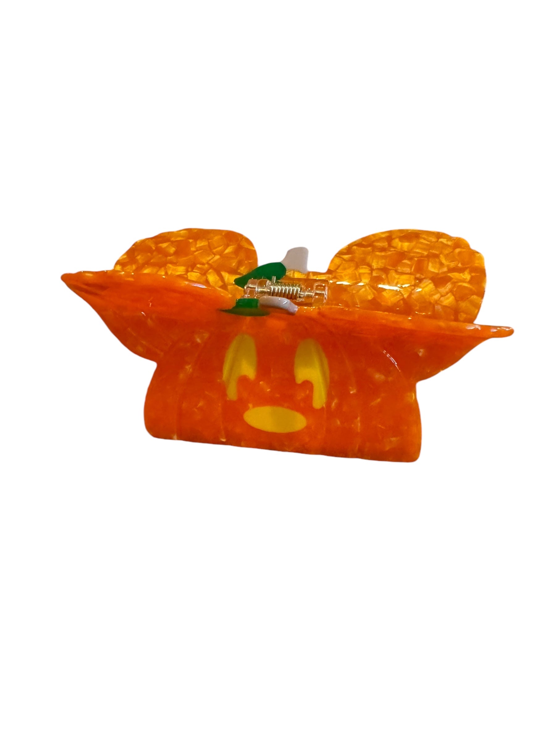 An orange pumpkin-shaped Halloween mouse ear claw clip against a white background