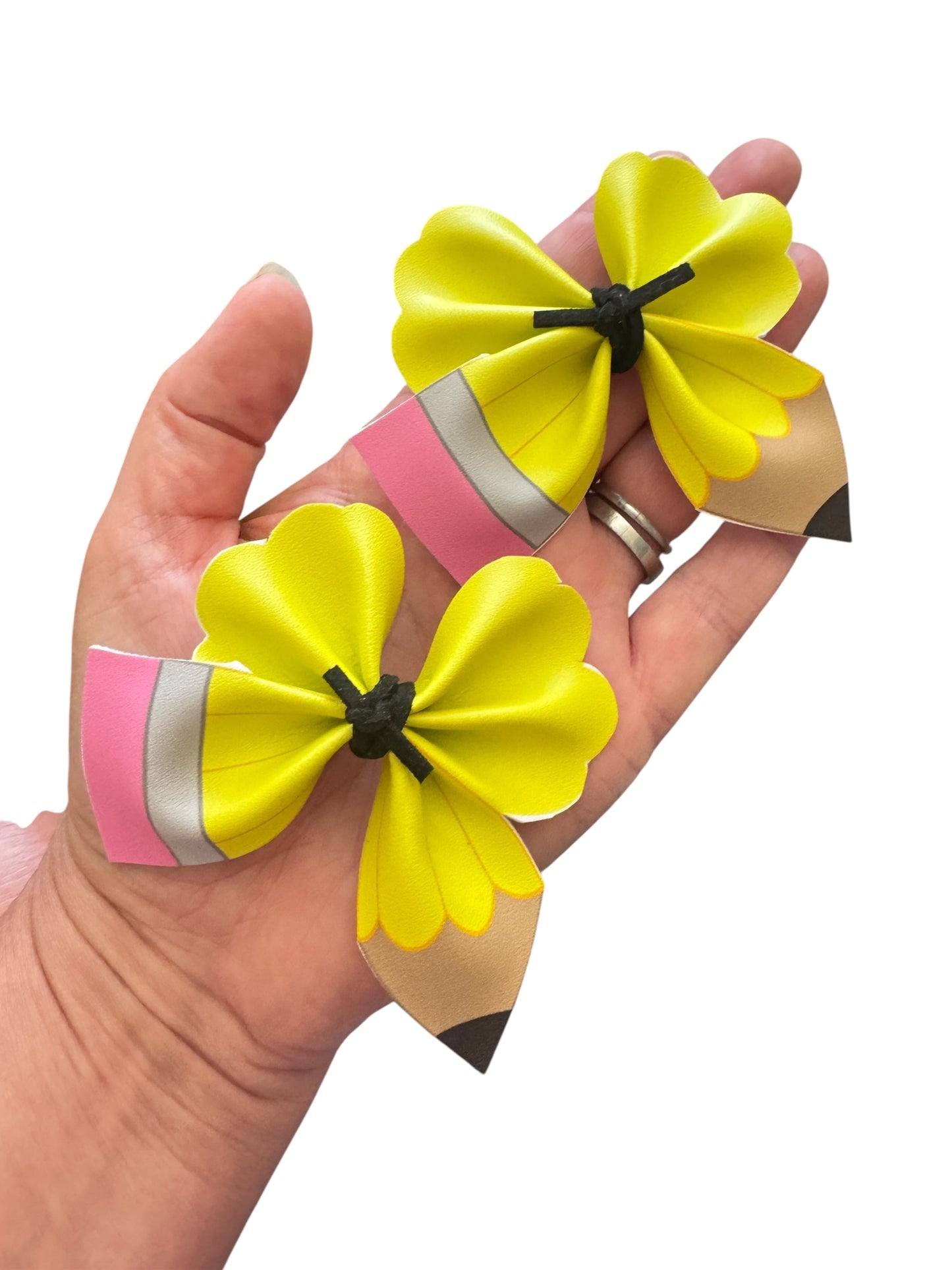 Yellow pencil hair clips on a white background in a hand