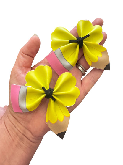 Yellow pencil hair clips on a white background in a hand