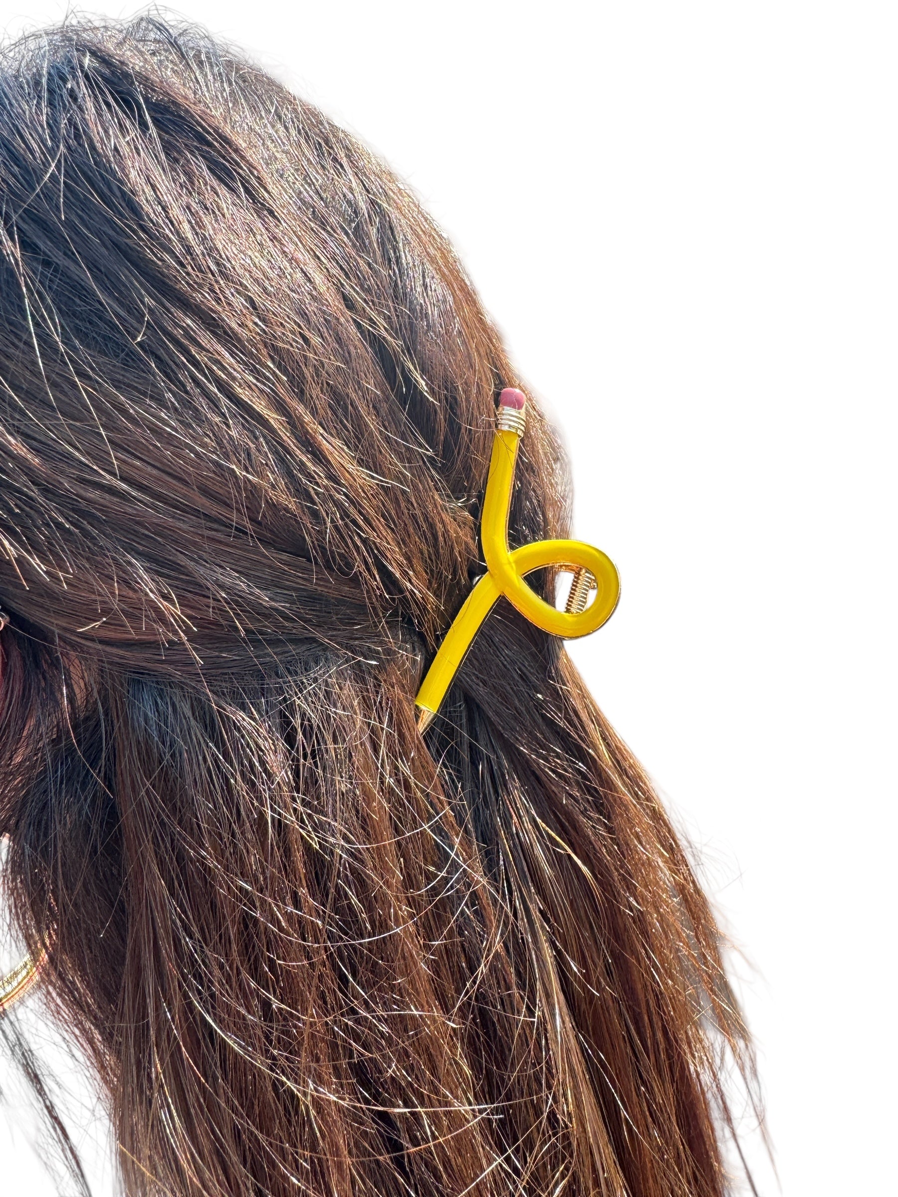 Yellow pencil hair clip in a person's hair on a white background
