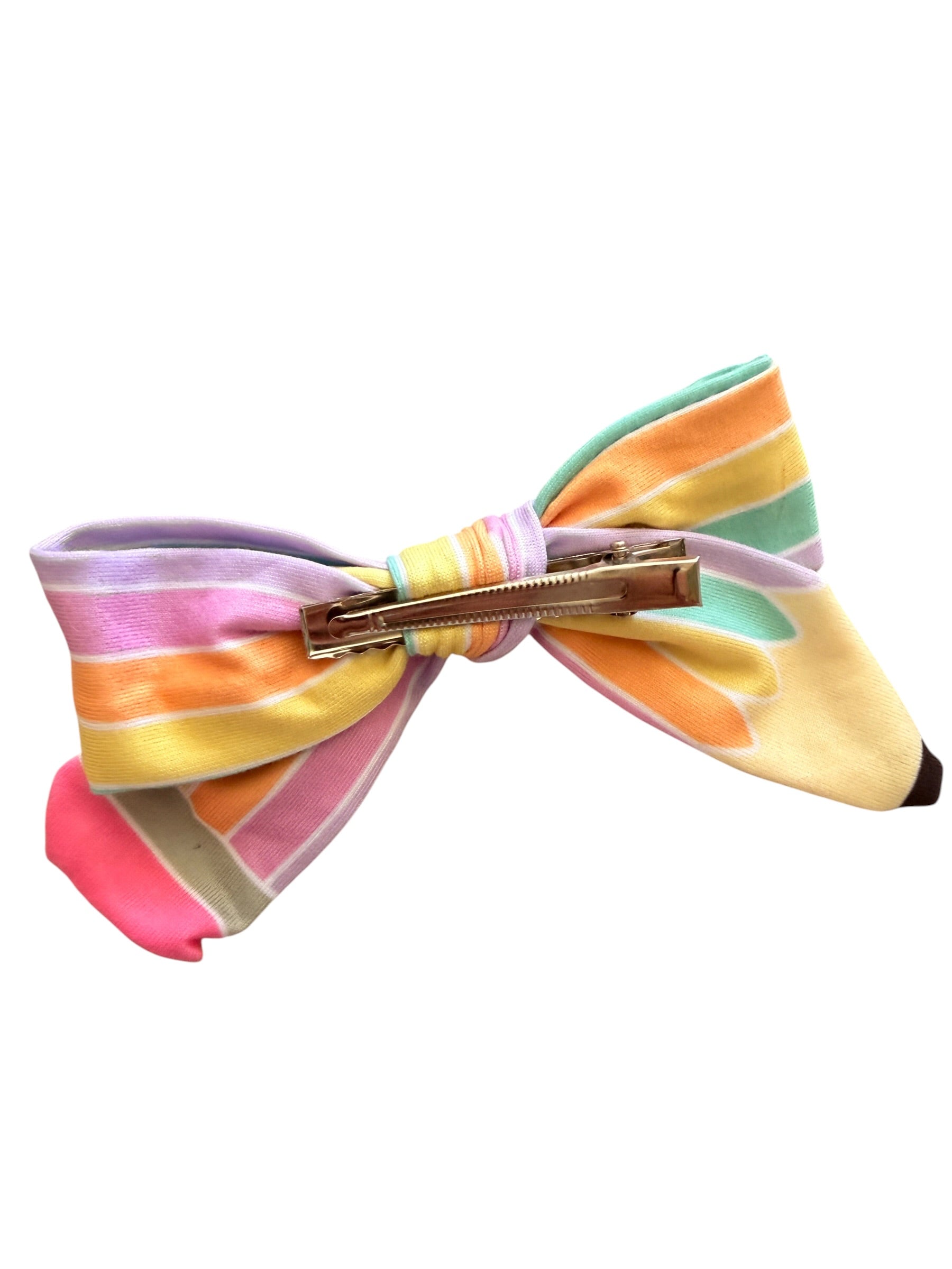 A pastel rainbow striped hair bow clip with a gold-toned metal spring clip, shown on a plain white background.