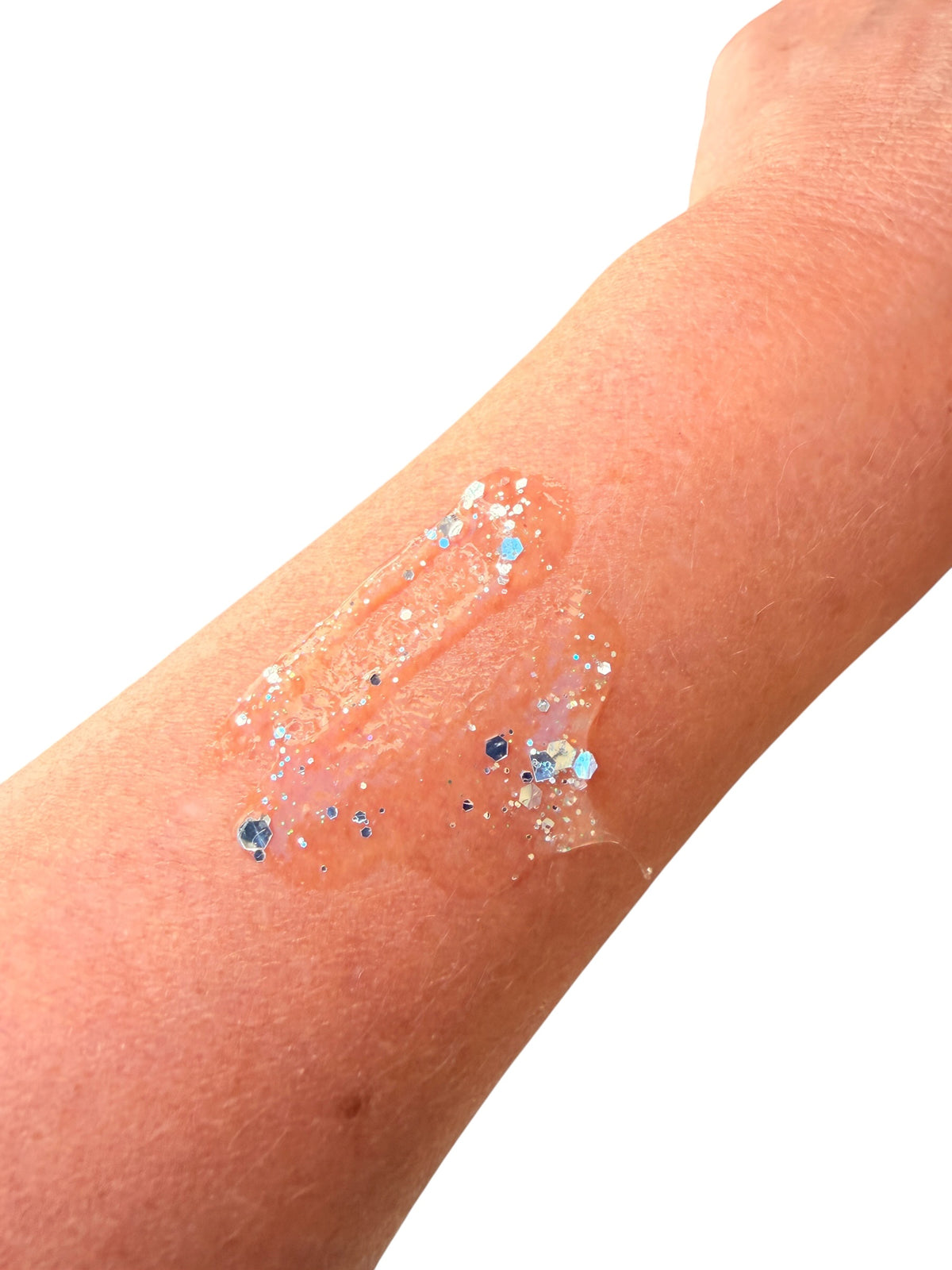A close-up of a person's forearm with a translucent silver-colored  hair gel, decorated with small blue, silver, and white glitter flakes, against a plain white background.