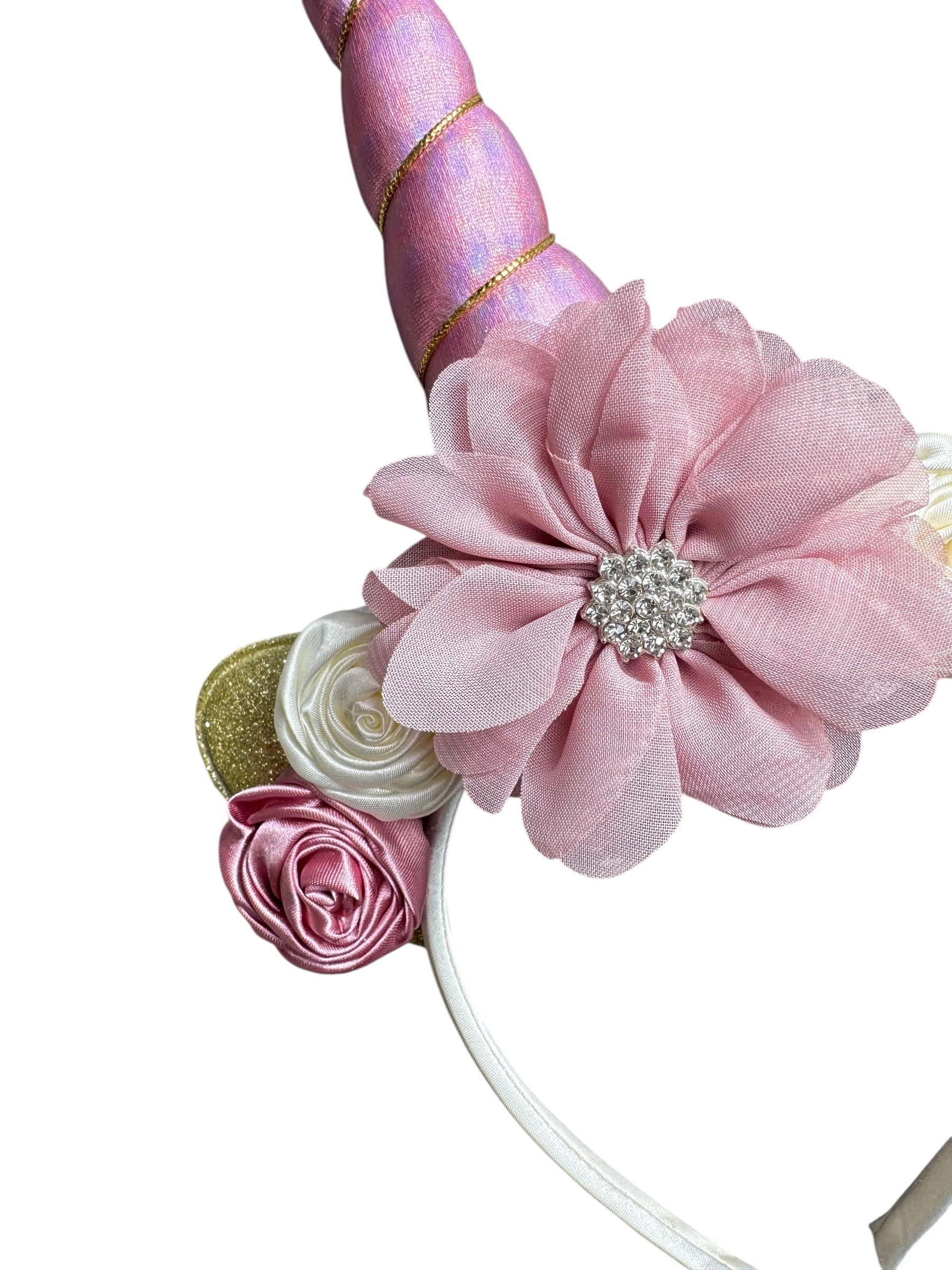 Unicorn horn headband with pink flowers and decorative elements on a white background