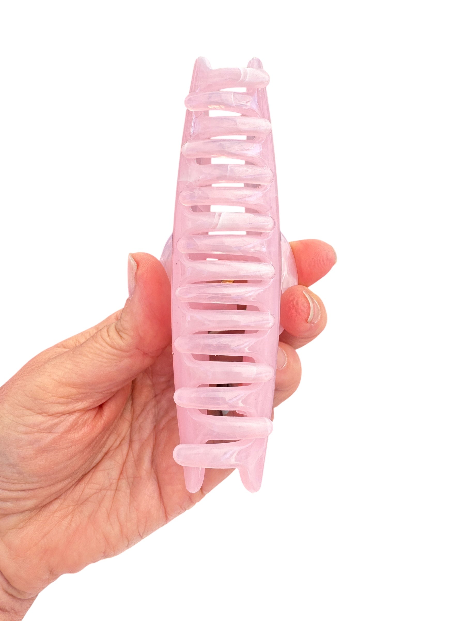Hand holding a pink hair comb against a white background