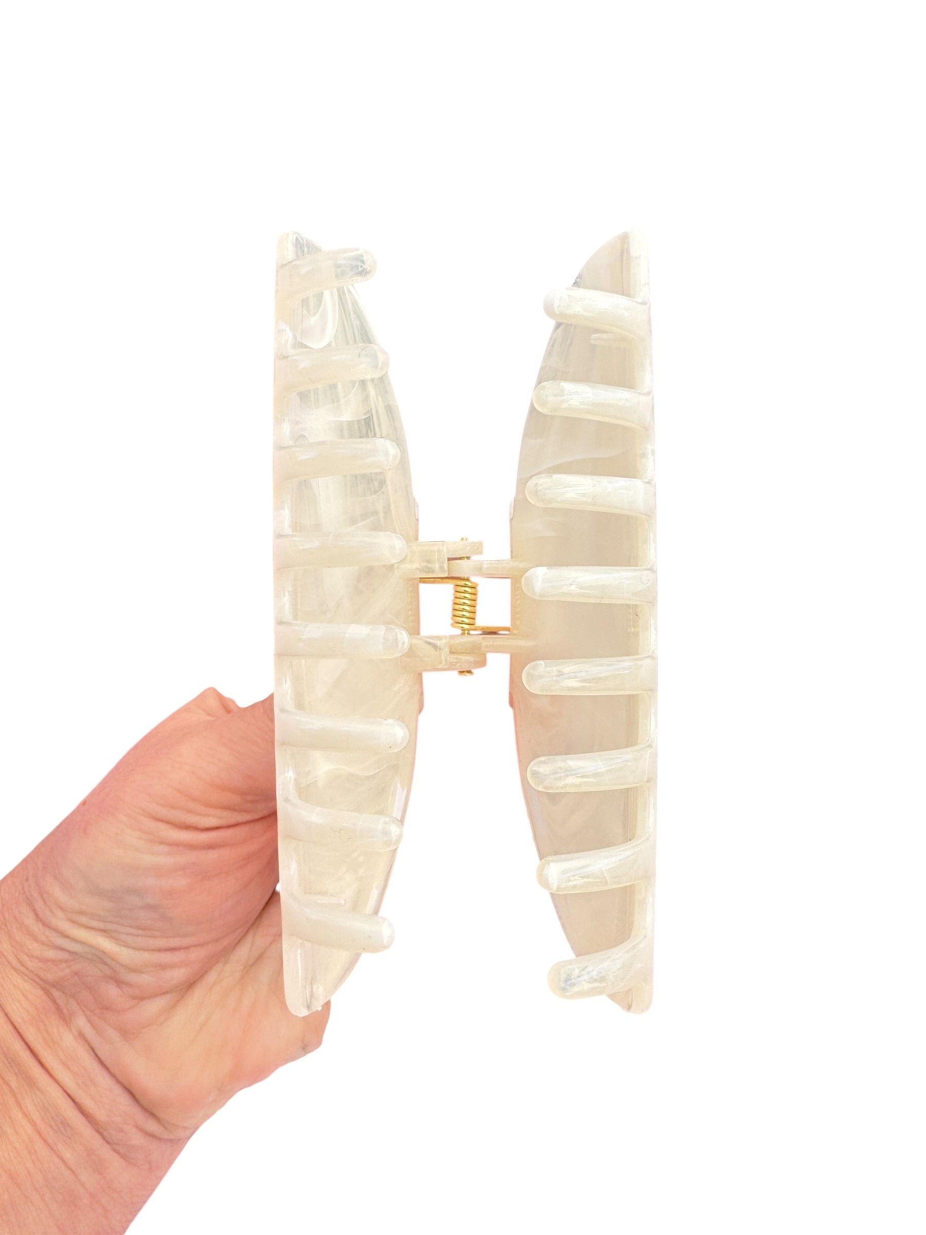 Hand holding a beige dental model against a white background
