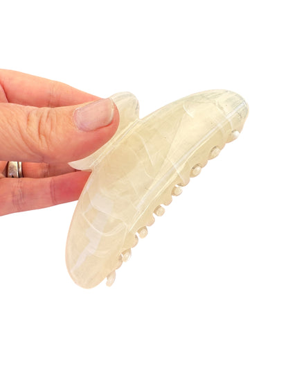 Beige slip-on shoe held by a hand on a white background