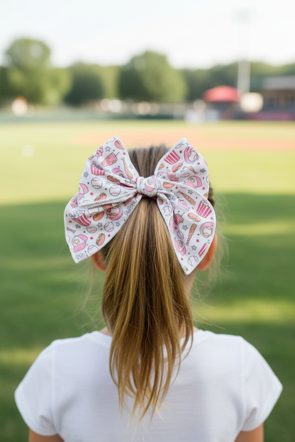Girl wearing pink baseball bow in half-up half-down hairstyle from behind